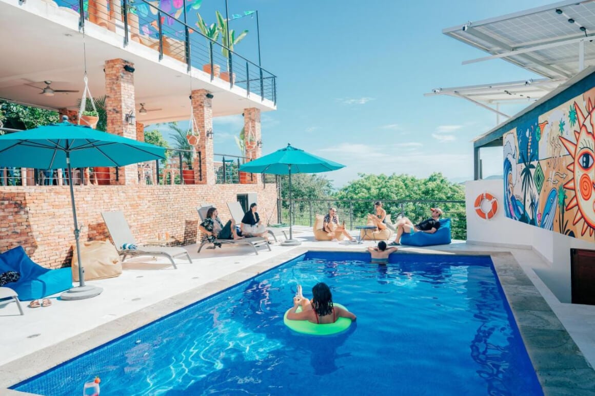 Viajero Sayulita Hostel's pool, with guests lounging and enjoying a swim