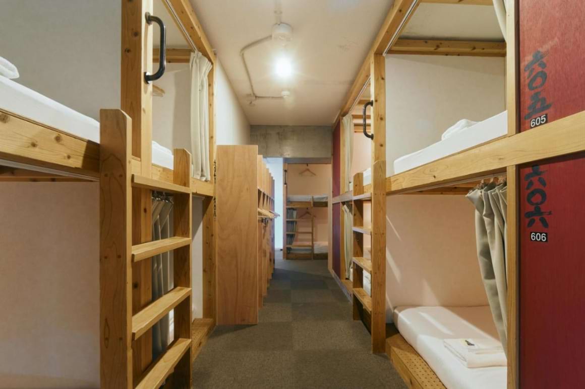 a long hallway lined with two-level beds in Common De Hostel and Bar