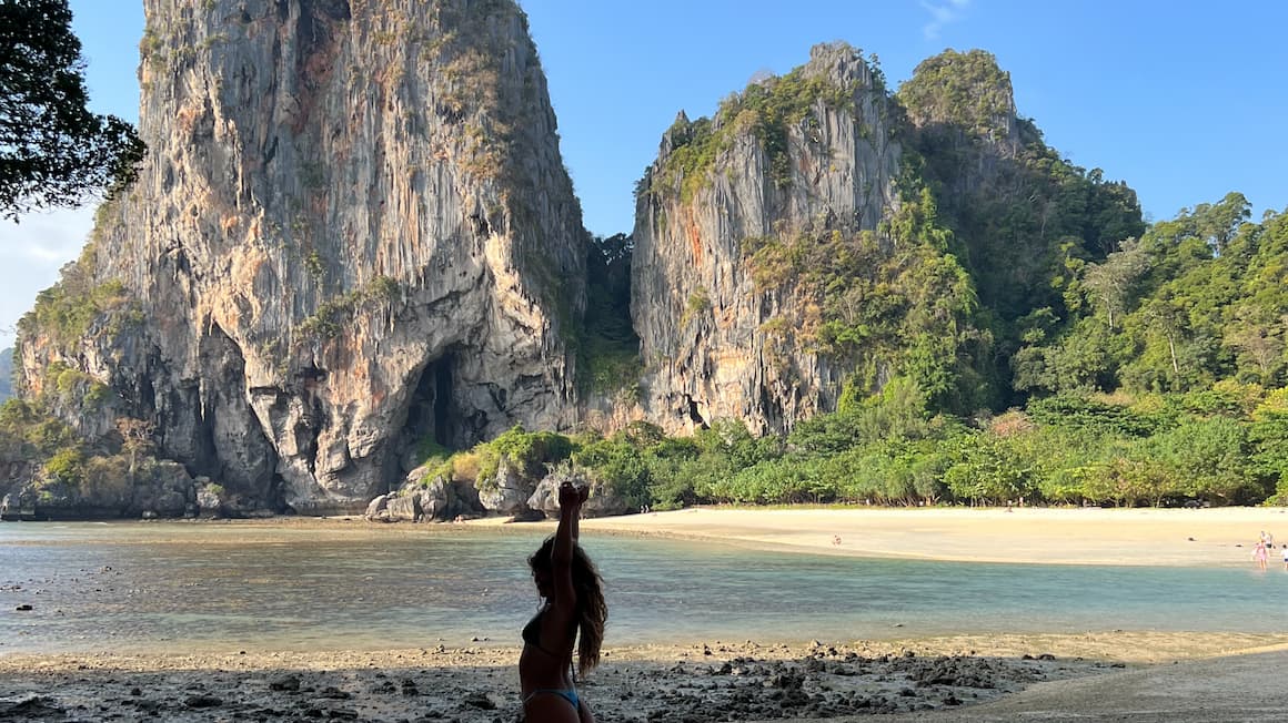 a girl at a secluded beach in Krabi, Thailand as the sun sets  