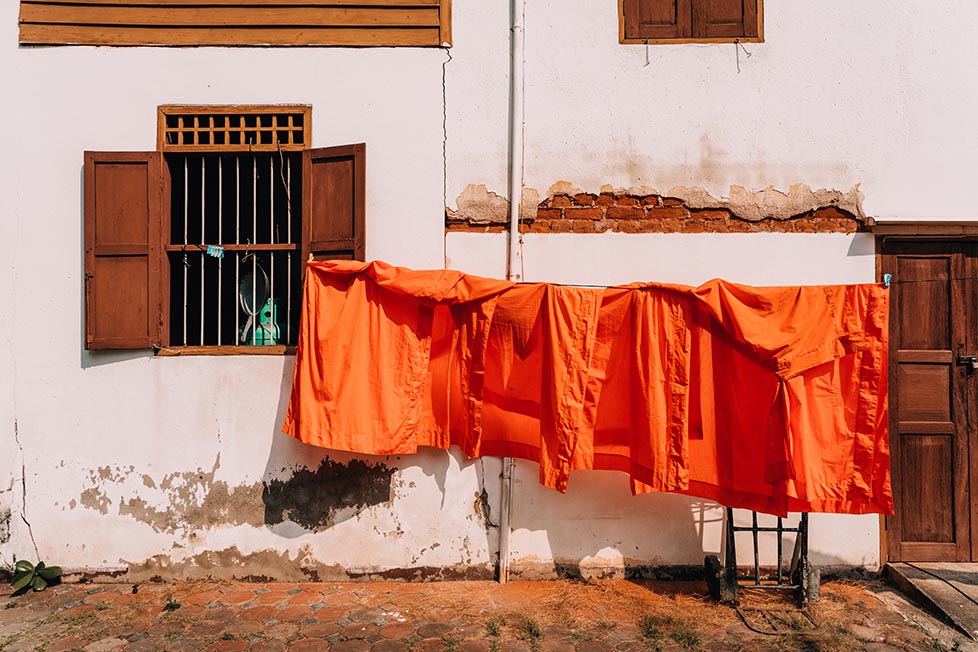 Monks orange robes hanging up outside a temple in Thailand