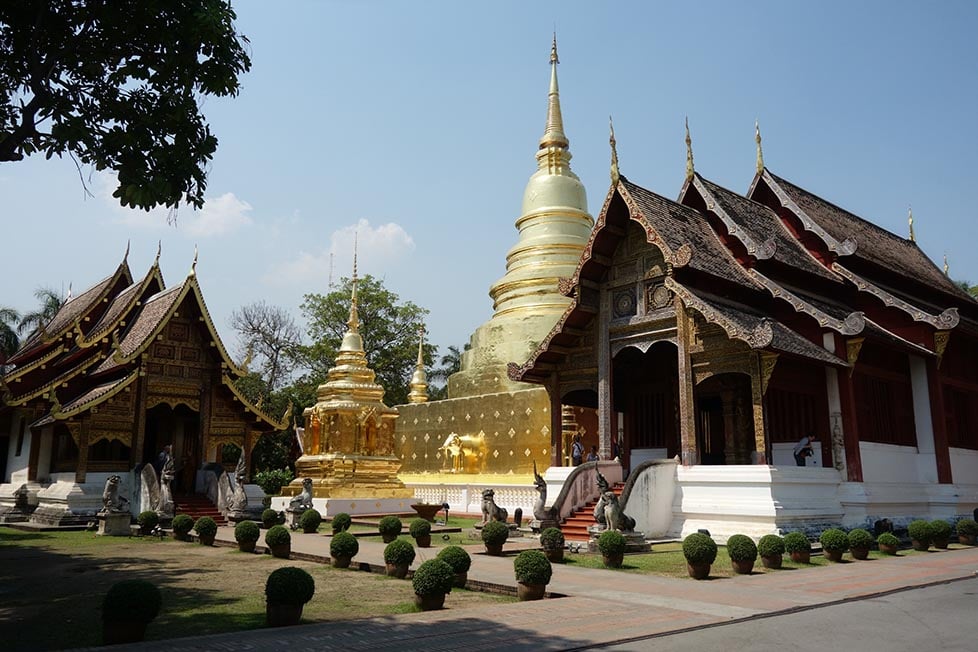 Ornate wooden temples and a golden stupa in Chiang Mai, Thailand