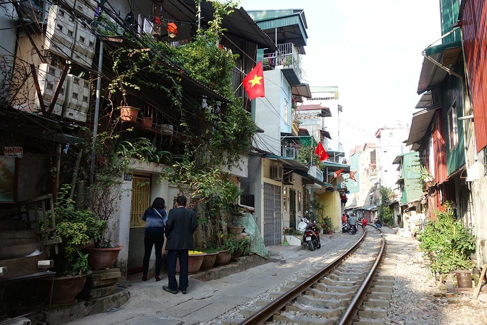A narrow street with a train track running down the middle in Hanoi, Vietnam
