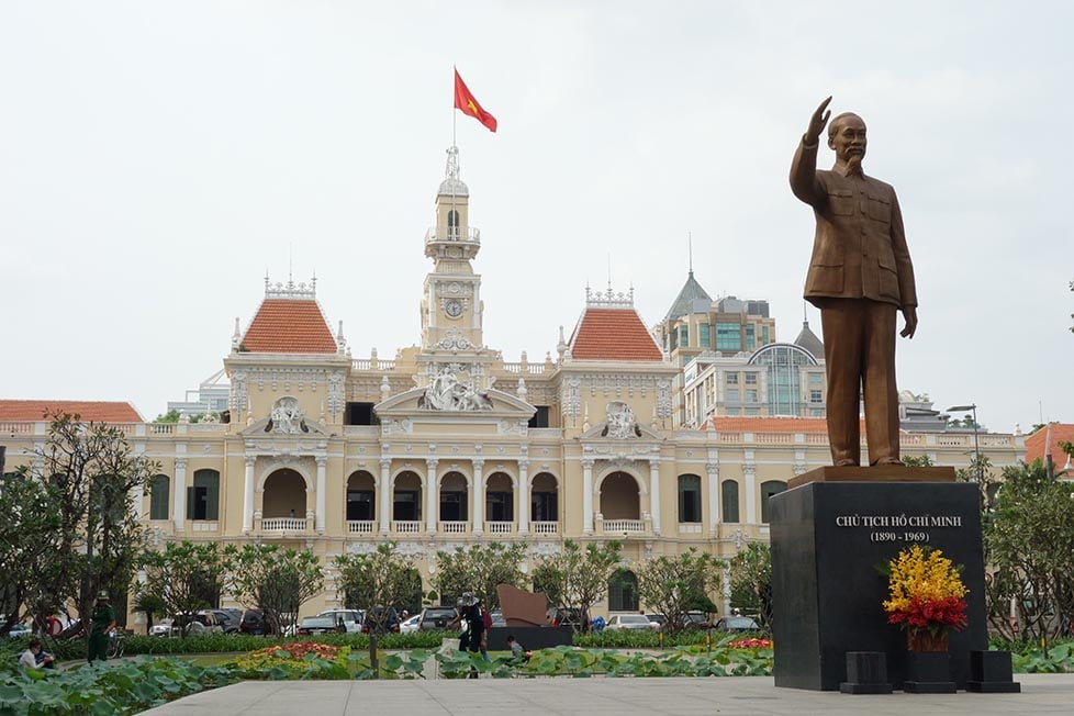 A statue of Ho Chi Minh outside of a large colonial building in Saigon, Vietnam