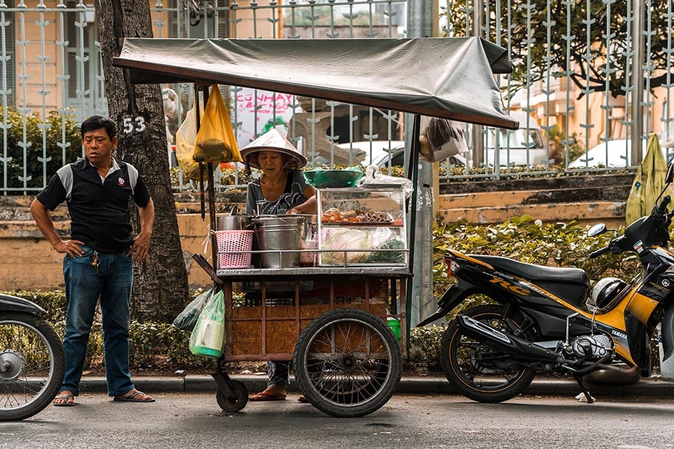 A person waiting next to a street food stall in Vietnam