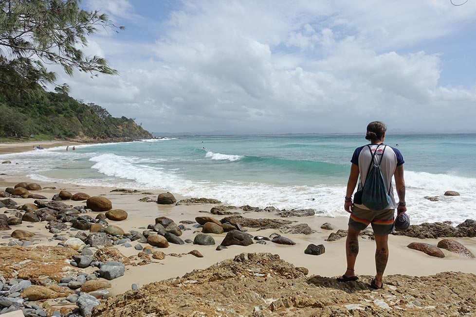 A person looking out over the beach with good surf waves in Byron Bay, Queensland, Australia