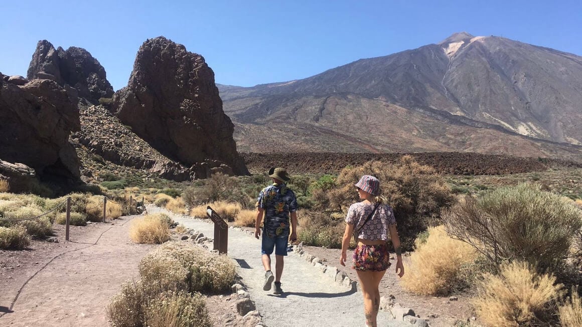 Two people walking towards mountains about to hike in Tenerife