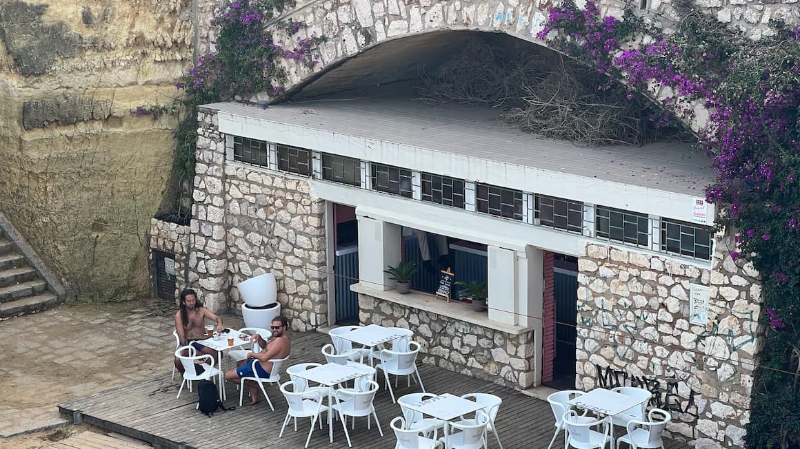 a few guys sitting at a table outside at a coffee shop in Portugal 