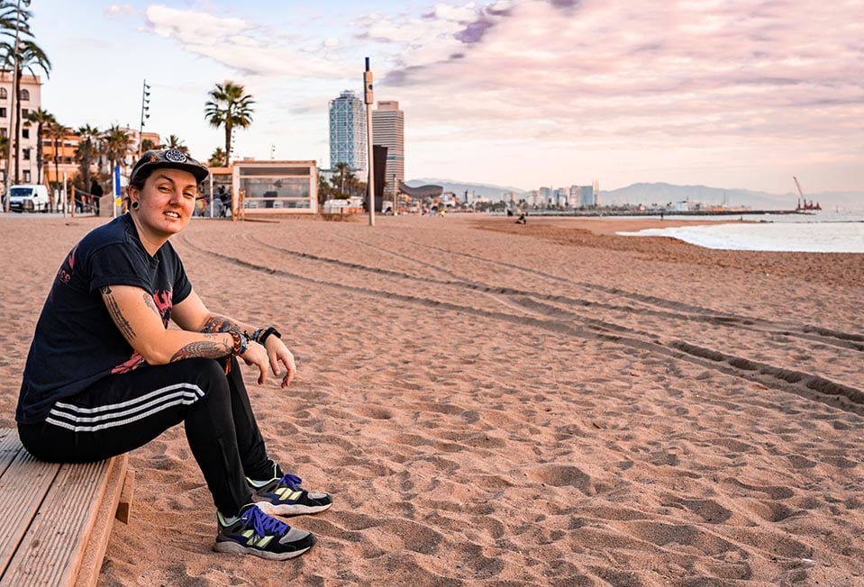 A person sitting on the beach at Barceloneta in Barcelona, Spain