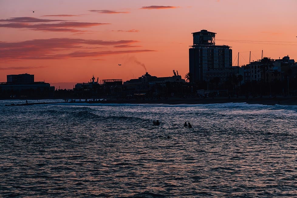 The sun setting over the beach of Barceloneta in Barcelona, Spain