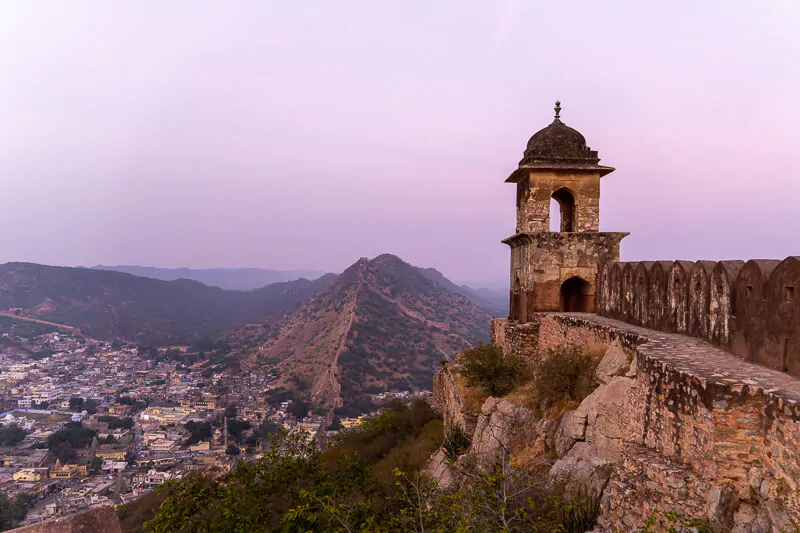 a purple colored sunset above the indian city of jaipur as seen from the amer fort