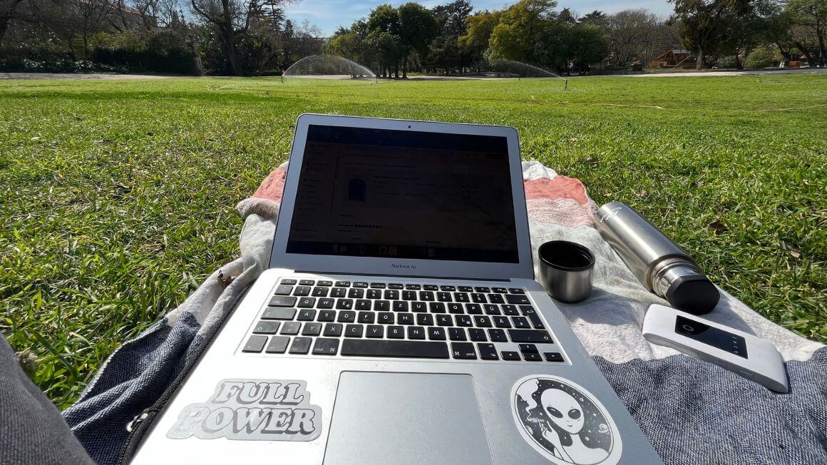remote working at the park with a laptop, portable wifi and hot tea in a thermos
