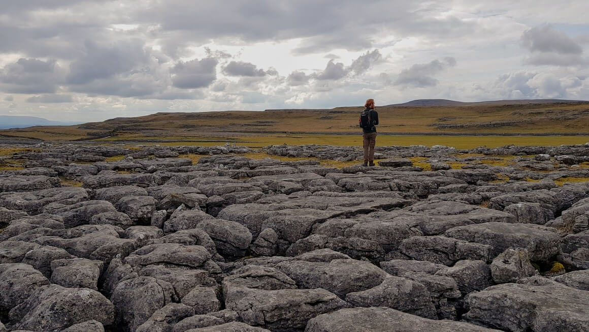 Man stood on limestone pavement in the Yorkshire Dales