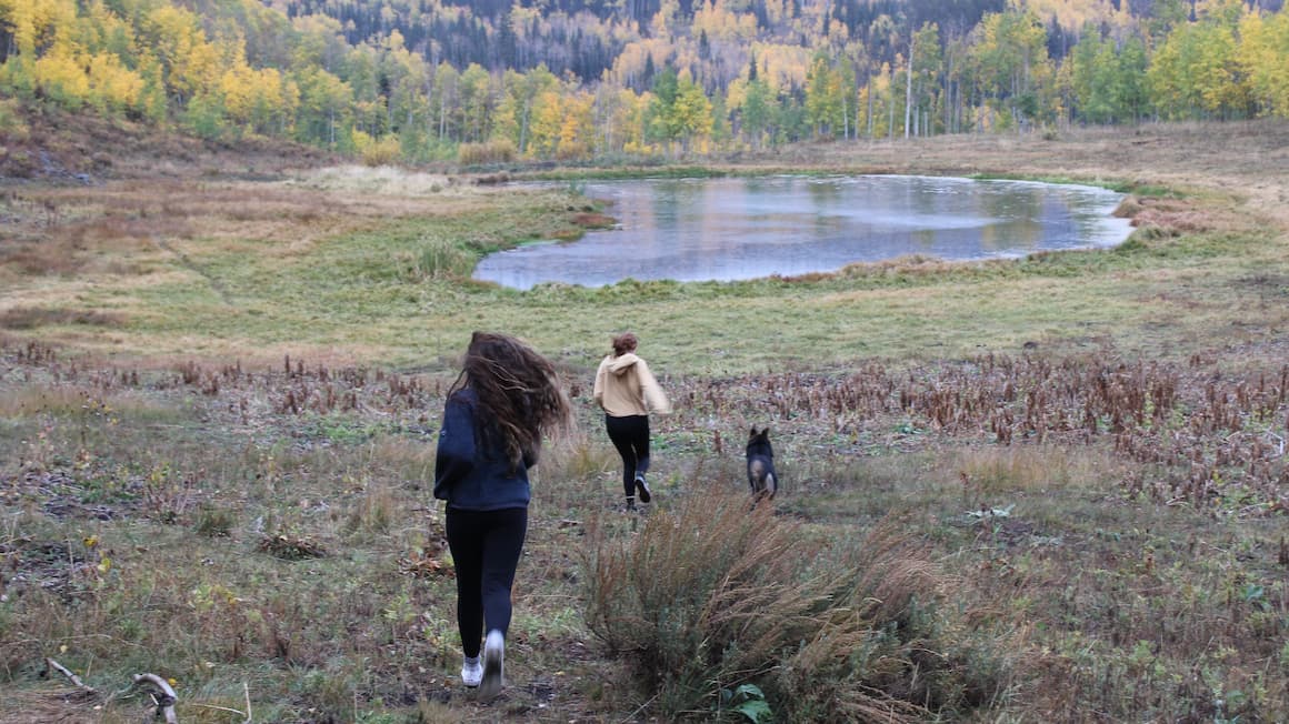 friends running through the forest to get to a lake United States of America.