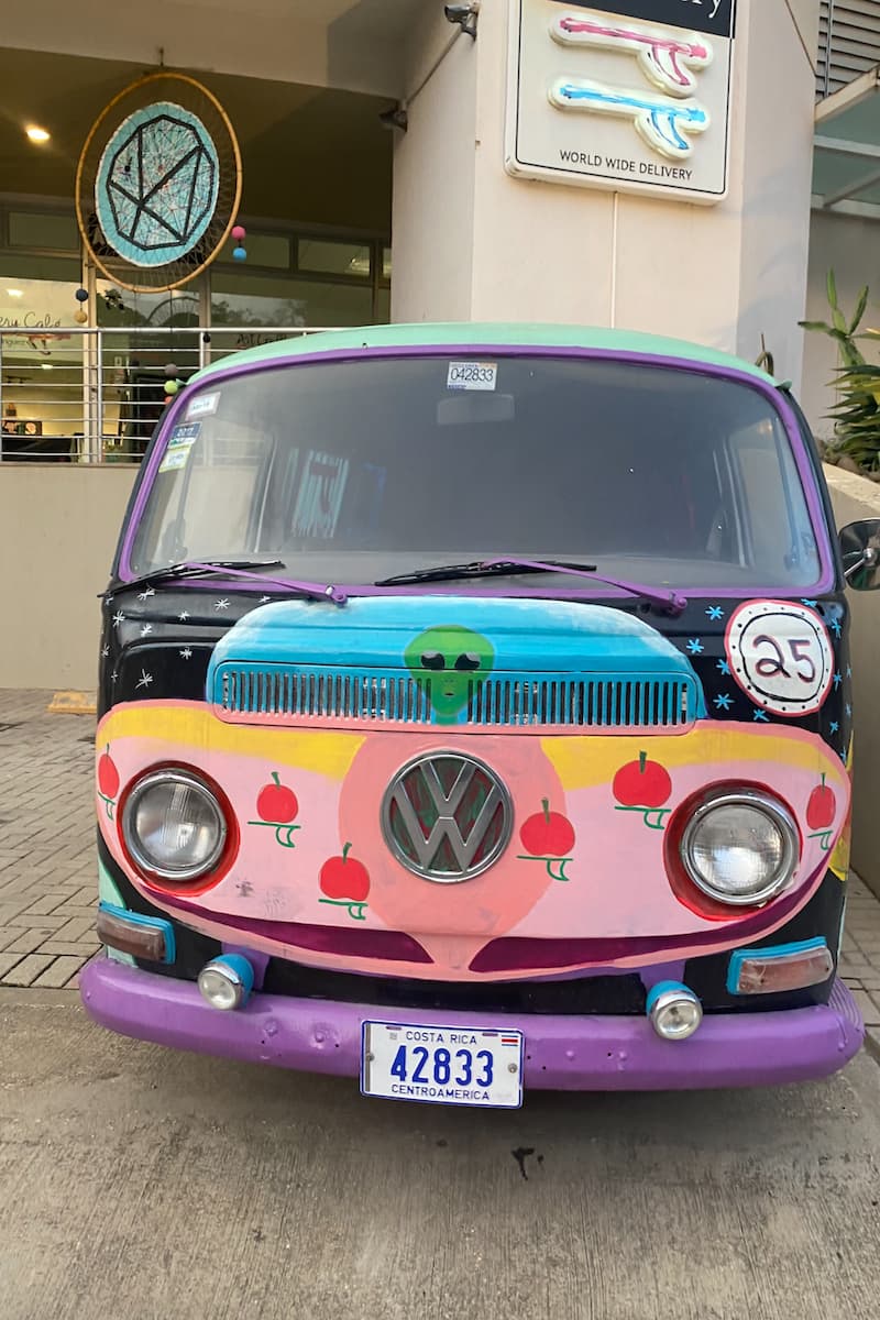 a colorfully painted volkswagen van in costa rica