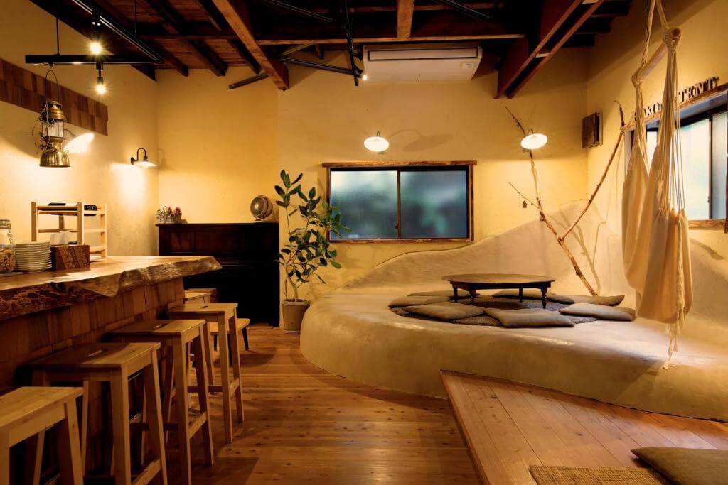Living space with two dining areas and a hammok hanging from the ceiling at Onsen Guesthouse HAKONE TENT 