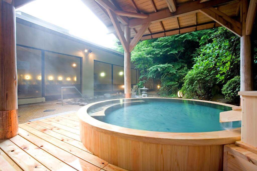 A wooden hot tub that's on a wooden deck in Yumoto Fujiya Hotel