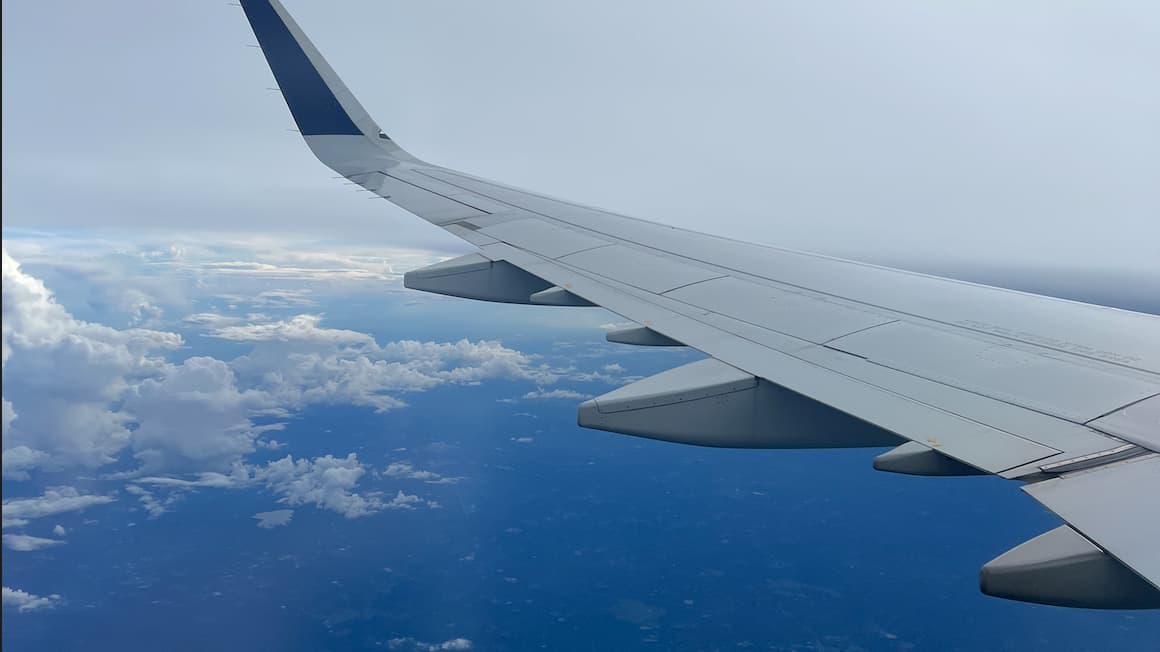 the wing of an airplane in the sky with views of clouds