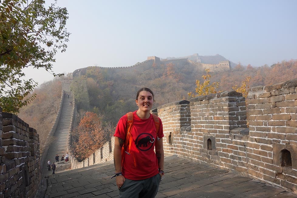 Nic standing on the Great Wall Of China with the wall and mountains behind them.