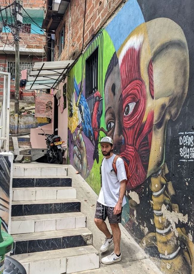 Backpacker walking on a street with graffities in Comuna 13, Medellin. 