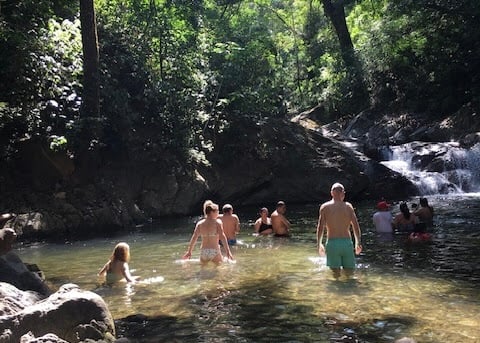 Waterfall in the jungle in Minca and people swimming.