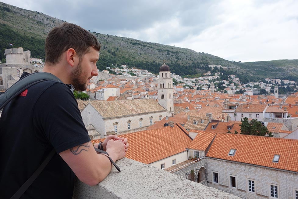 A man looking out over Dubrovnik, Croatia, from the city walls.