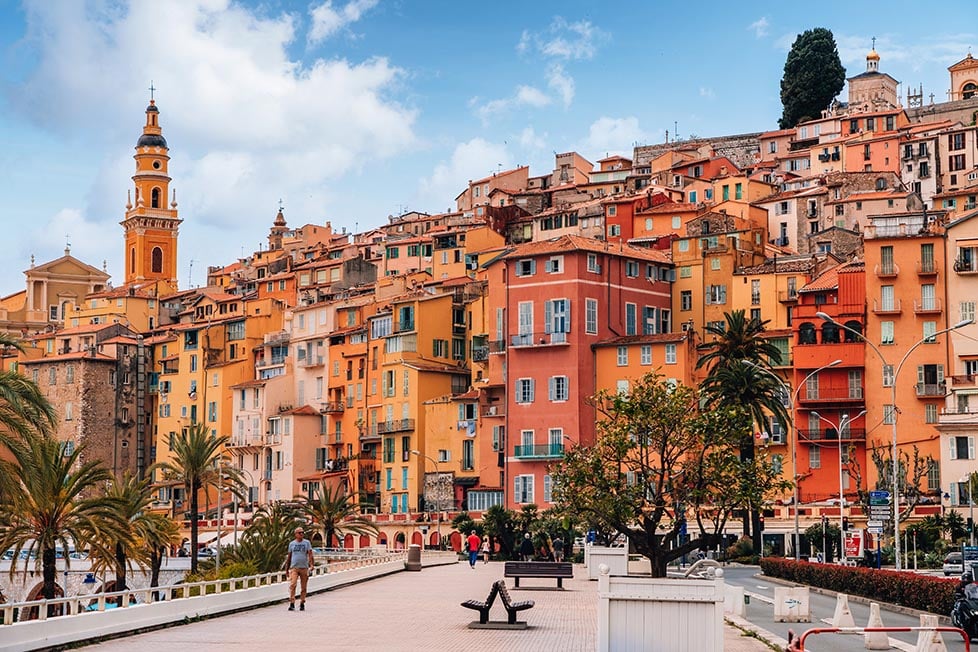Looking down the sea front to the layered red and orange buildings of Menton, France