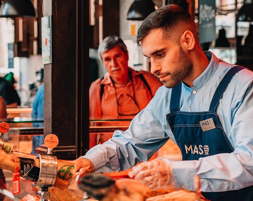 A man working on the jambon counter in a market in Madrid, Spain