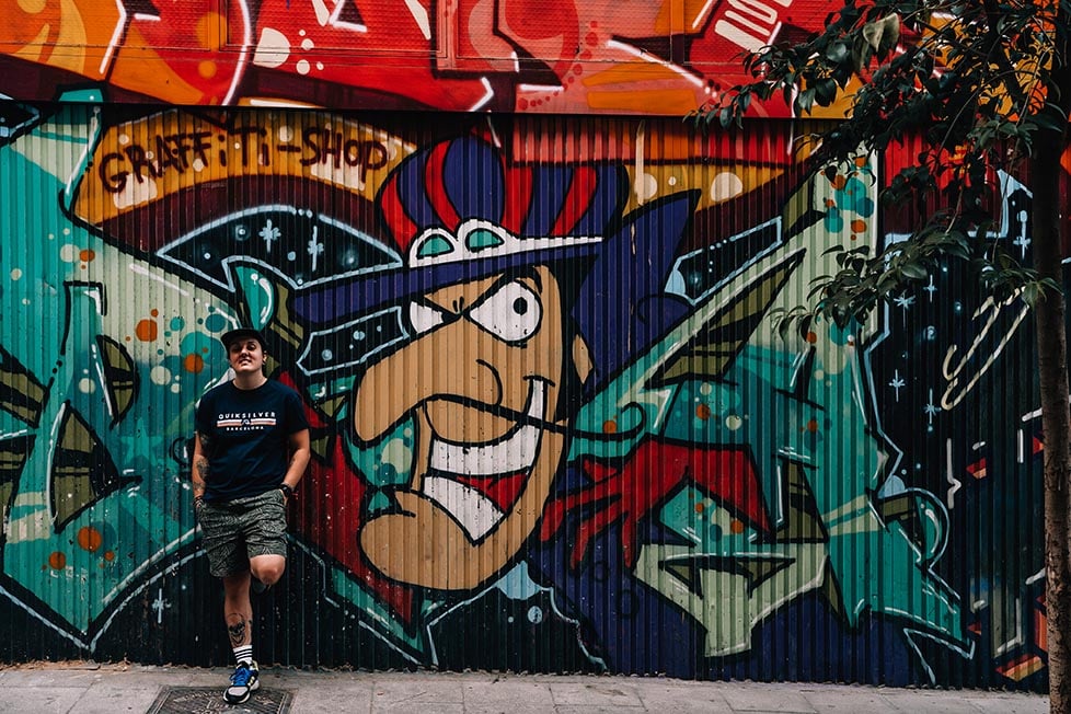 Nic standing next to street art of Dick Dastardly in Madrid, Spain.