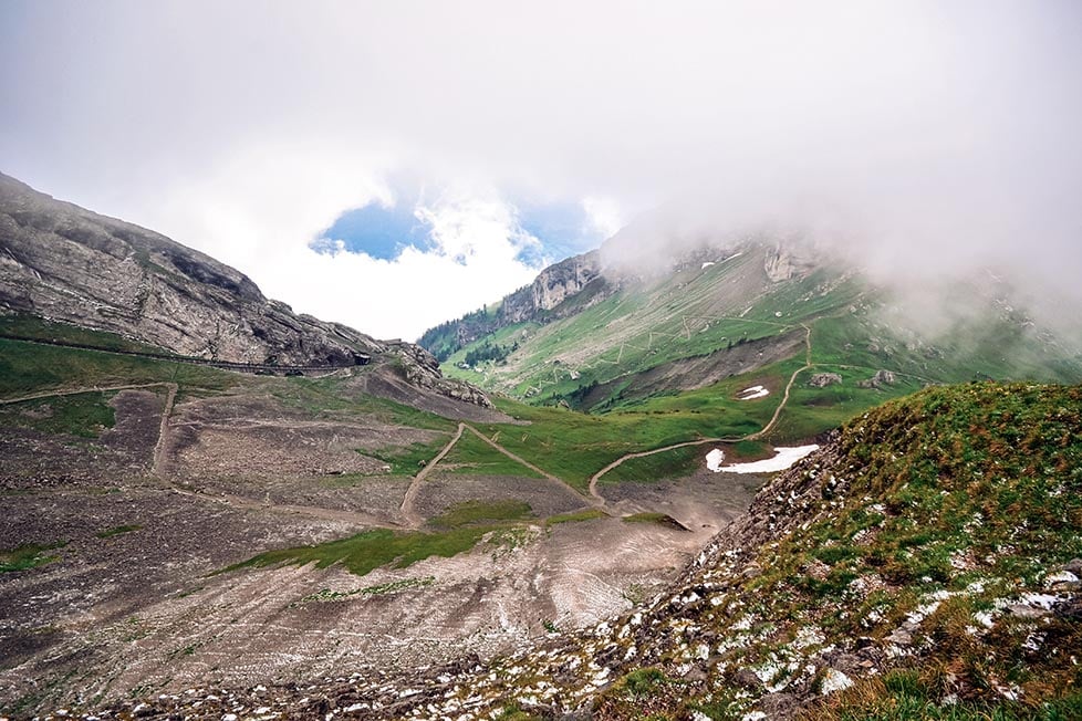 Looking down a valley with steep walking tracks on Mt Pilatus in Lucerne, Switzerland.