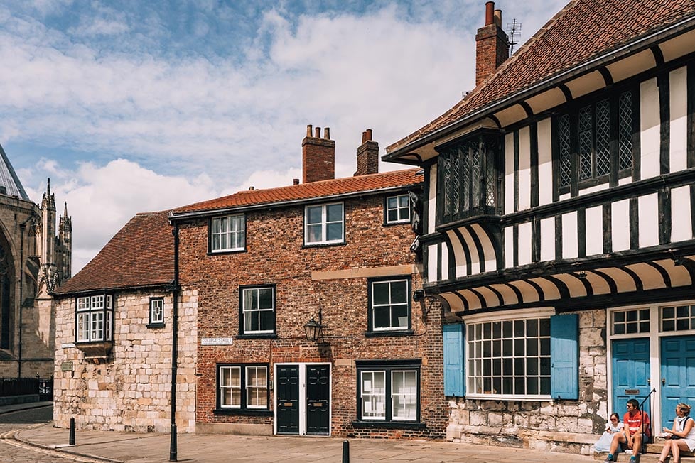 A wooden framed Tudor building next to some old brick buildings in York, England, United Kingdom