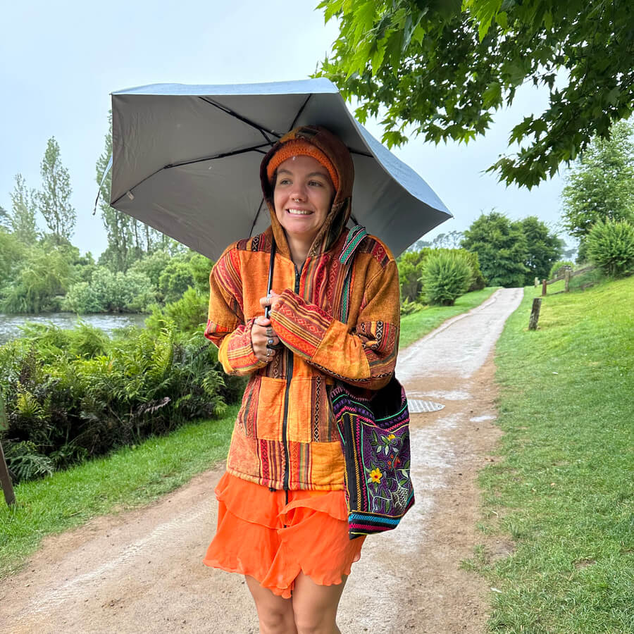 Audy walking with jacket and umbrella in the rain in New Zealand