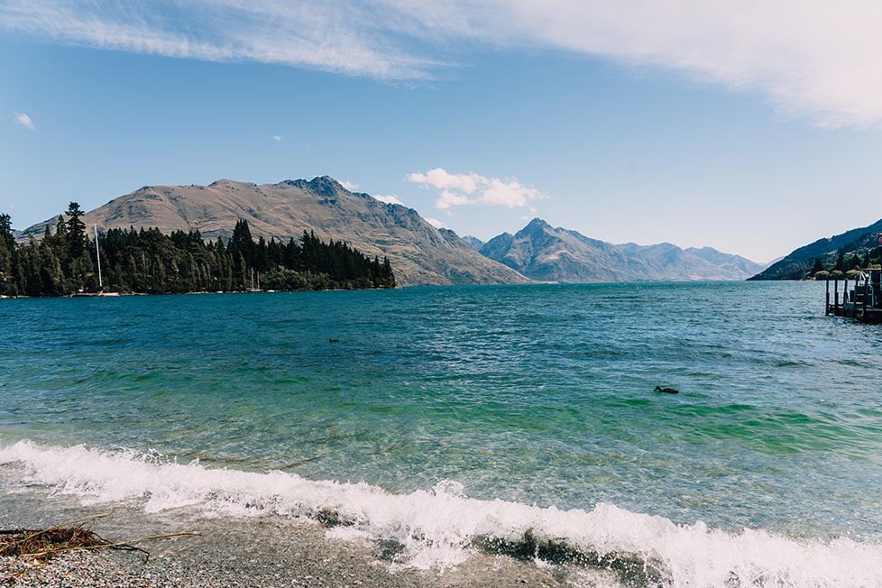 The green-blue waters of the lake and the Remarkables mountain range beyond in Queenstown, New Zealand