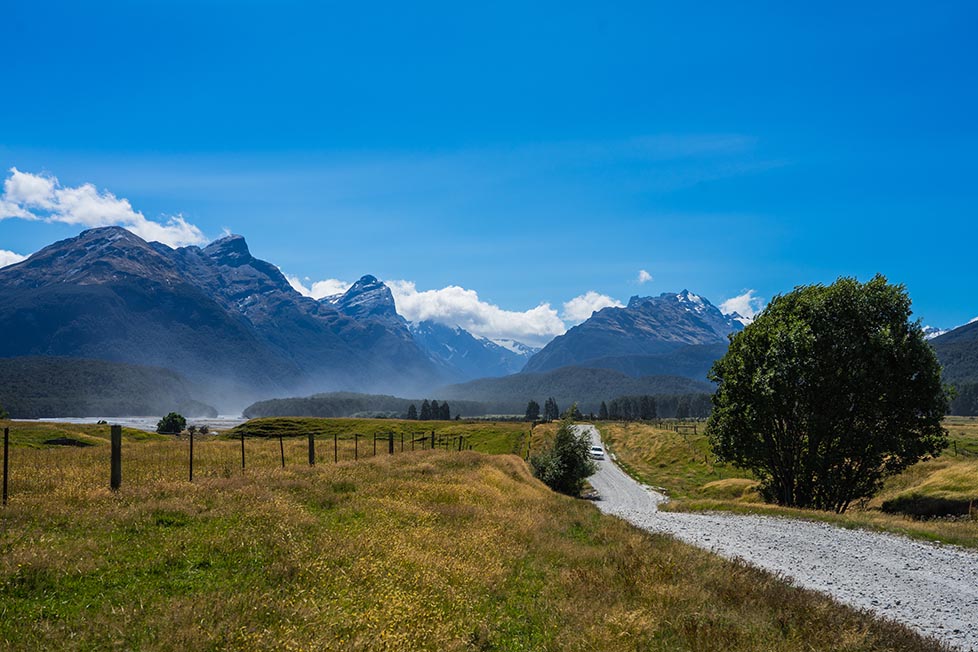 A dirt track leading to mountains in Queenstown, New Zealand