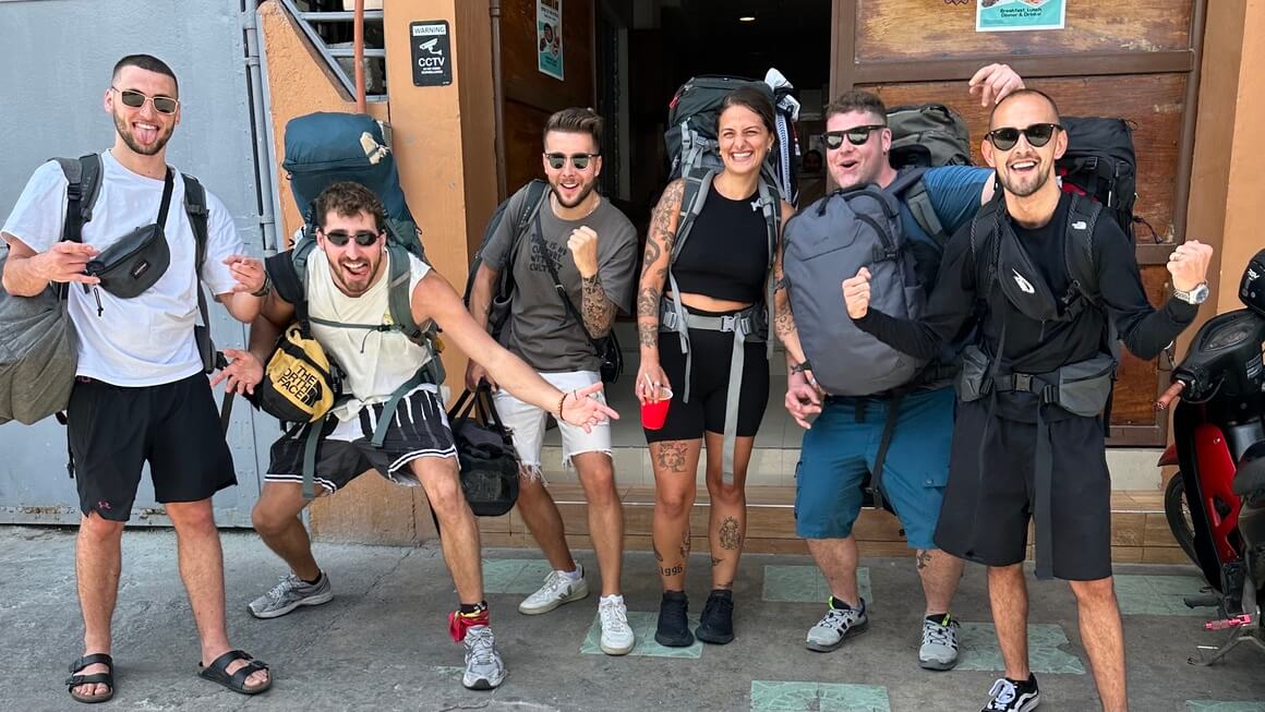 six people outside a hostel in Italy with their backpacks. 