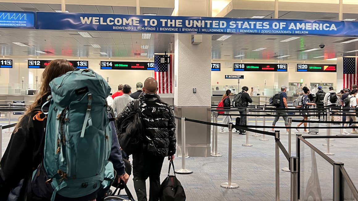 a girl with a backpack walking through the airport at miami international airport in florida, usa