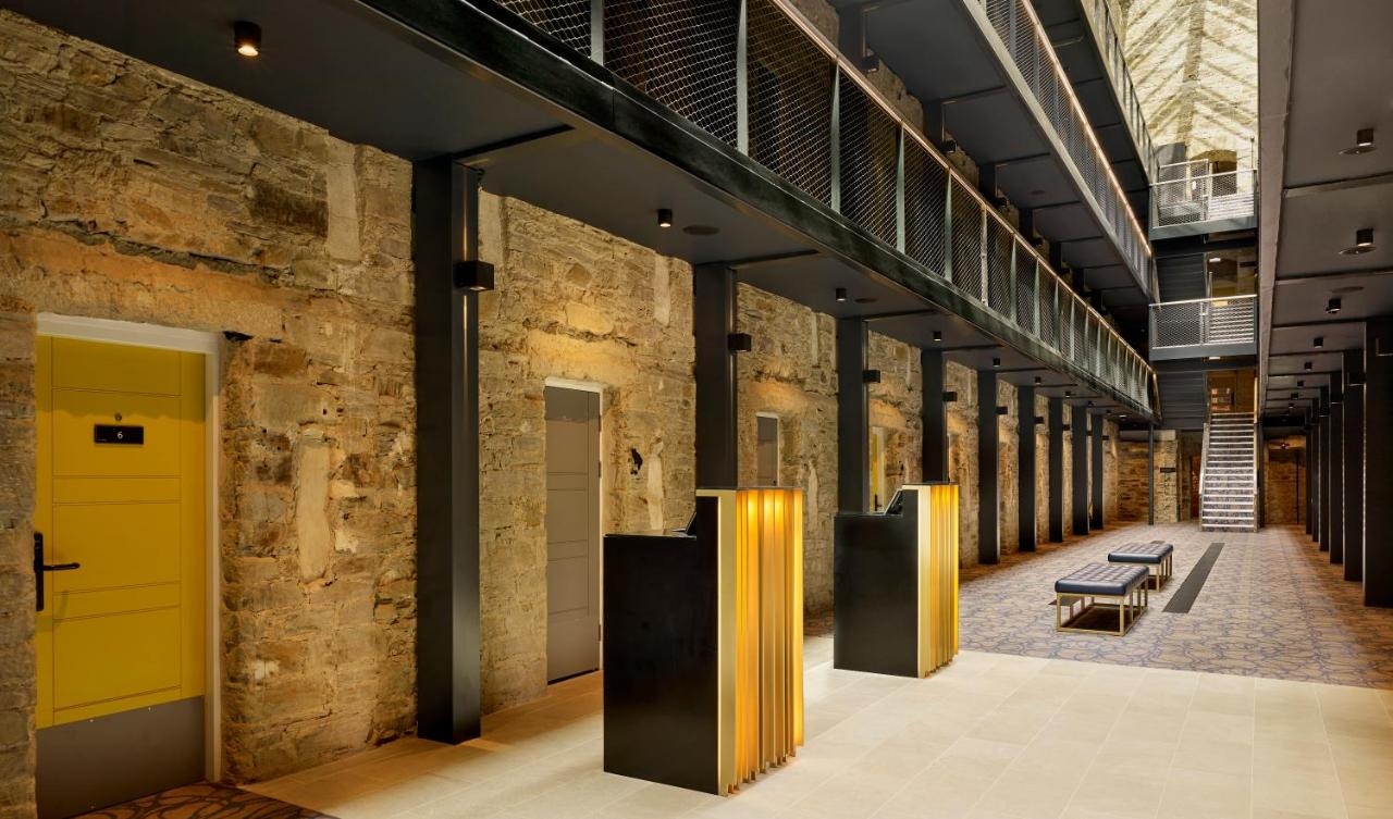 A long hallway with a row of yellow doors on either side in Bodmin Jail Hotel, UK