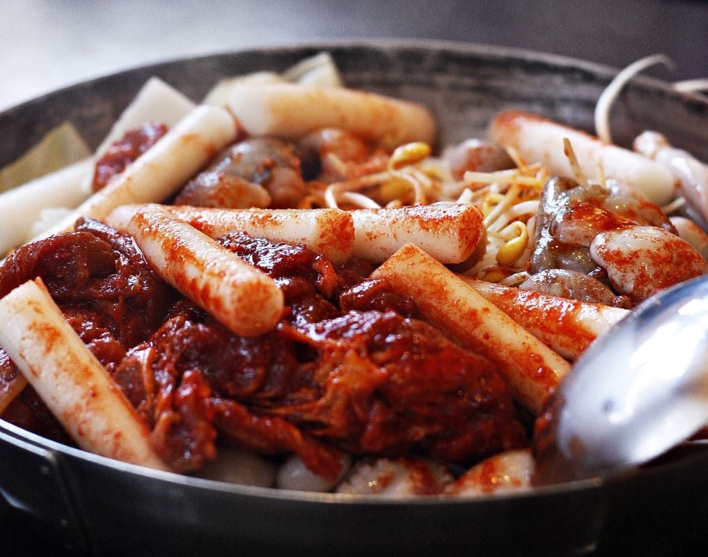 a plate of meat and cylinder shaped noodle looking pieces in south korea