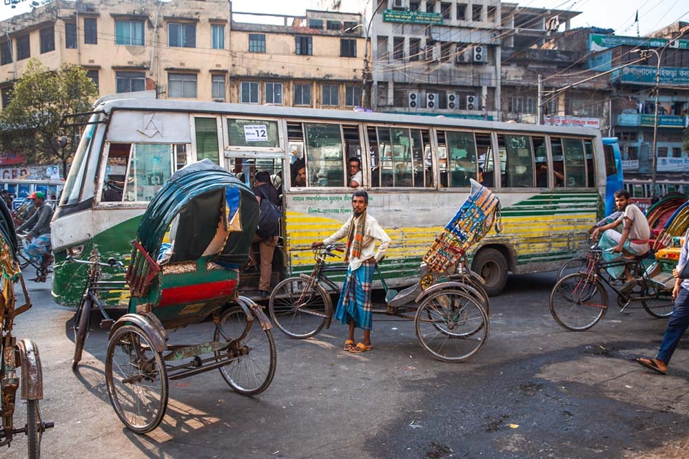 an old bus and several cycle rickshaws in old dhaka bangladesh