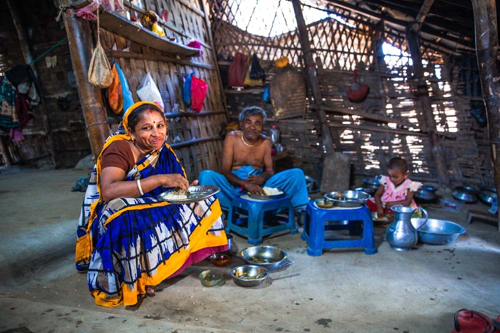 a woman and her husband in child posing for the camera in a home in bangladesh