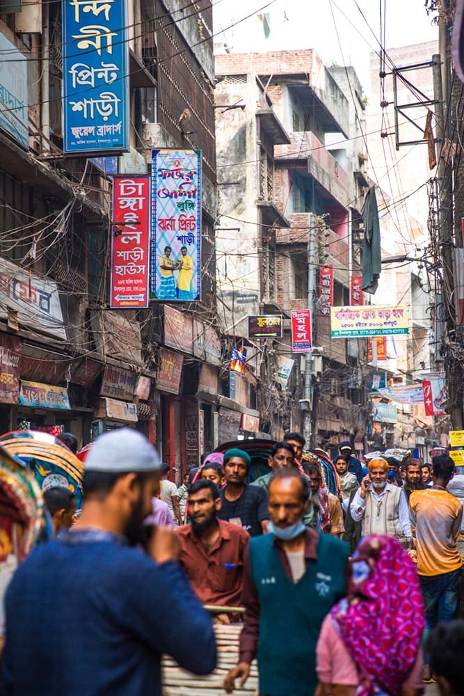 shot of a bunch of men walking down a busy street in dhaka bangladesh