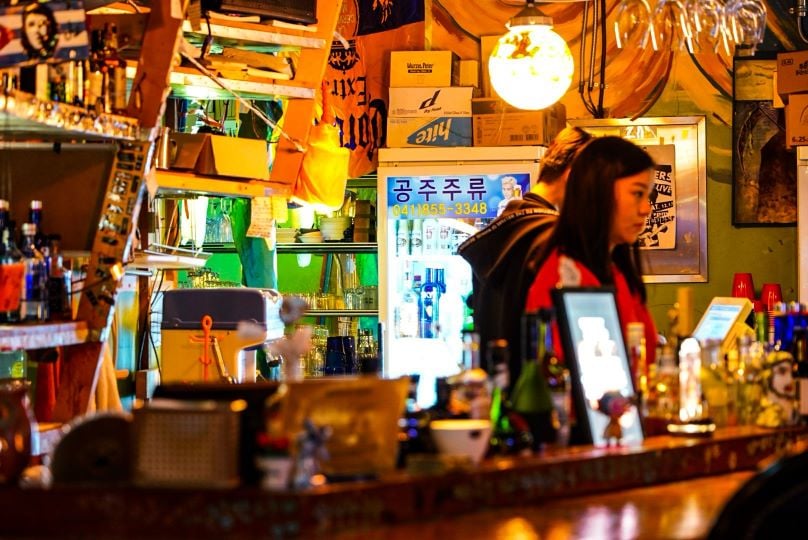 woman serving liquor at a bar in south korea