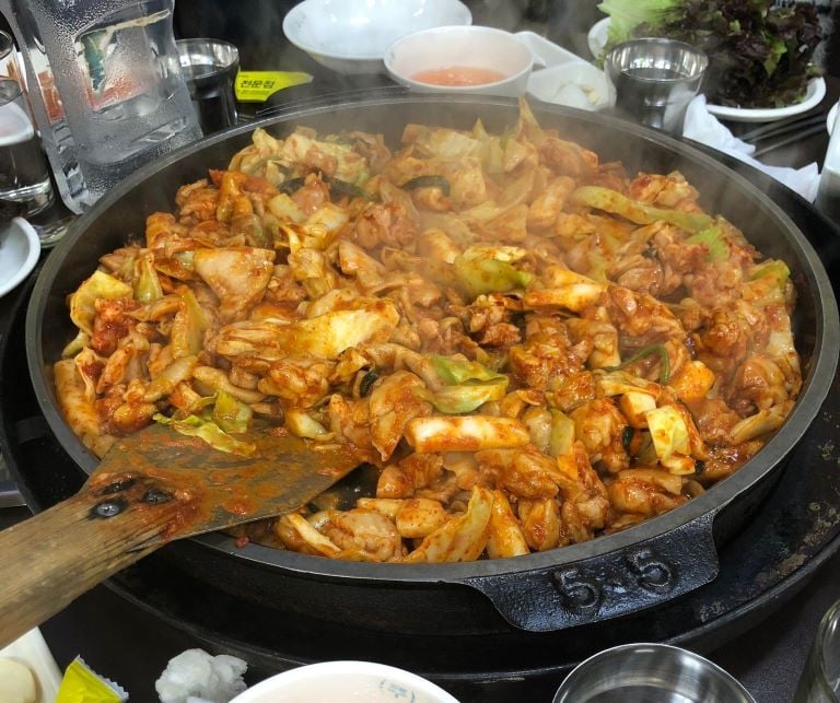 a popular meat and vegetable dish in a black pan in south korea