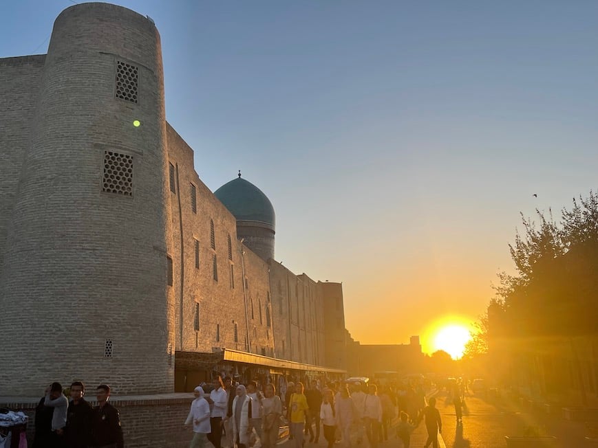 people walking in bukhara uzbekistan at sunset