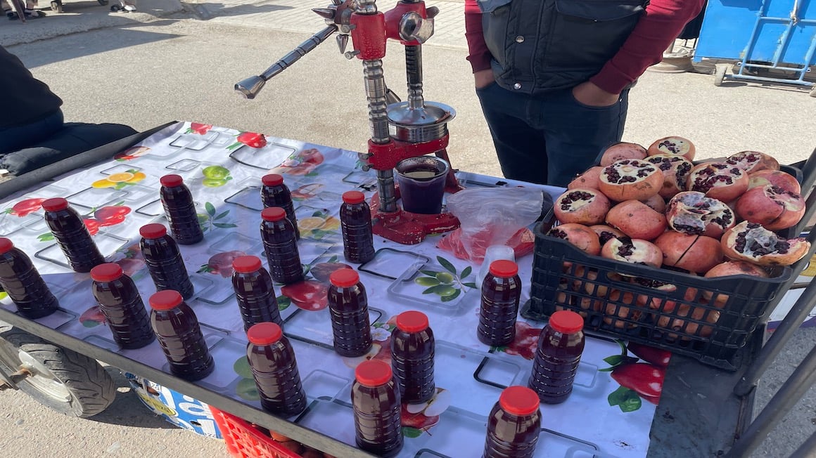 man selling pomegranate juice street food in uzbekistan