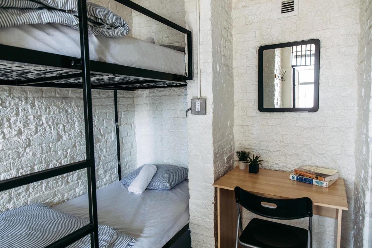 A small room with bunk beds and a desk in Hi-Ottawa Jail Hostel, Ottowa, Canada
