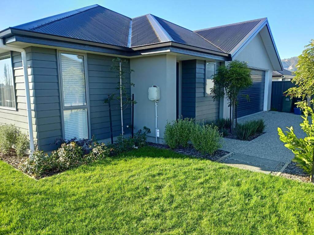 A house with a lush green lawn in front of it