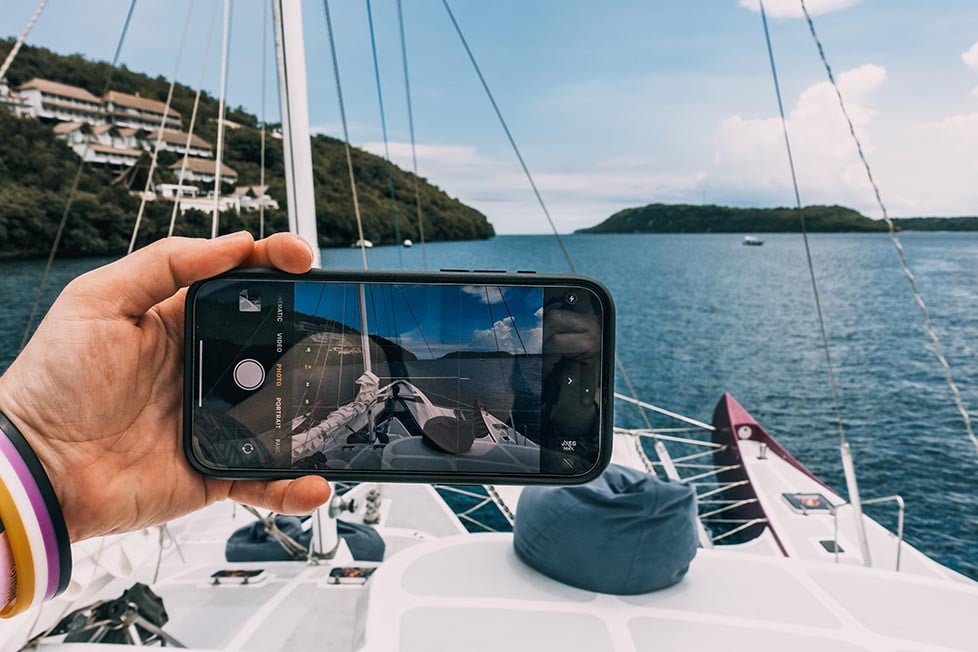 Taking a photo on my phone of a catamaran boat on a sunny day