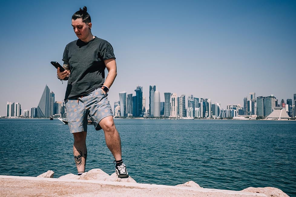 Nic stood by the water edge in front of the Doha skyscrapers