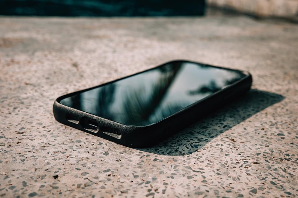 A close-up of a cell phone lying on a gray granite top