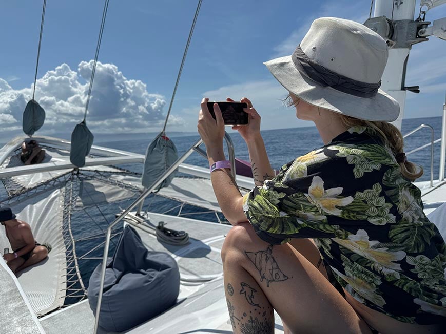 woman on a catamaran taking a photo